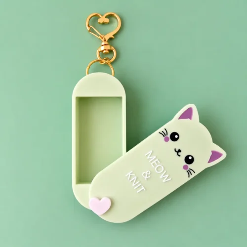 Green cat-shaped Meow & Knit Magnetic Notions Case with the lid open and a gold heart keychain clasp