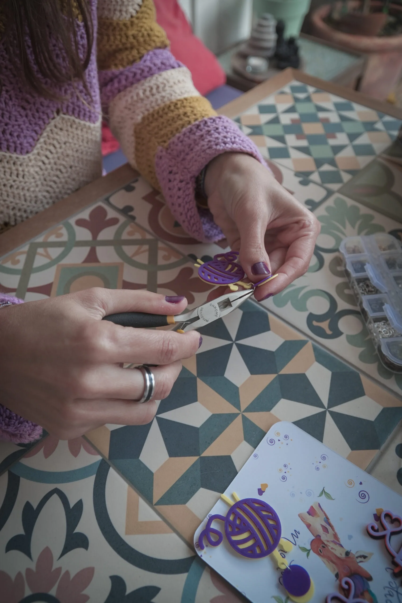 Manos de artesana montando un accesorio para tejer con alicates