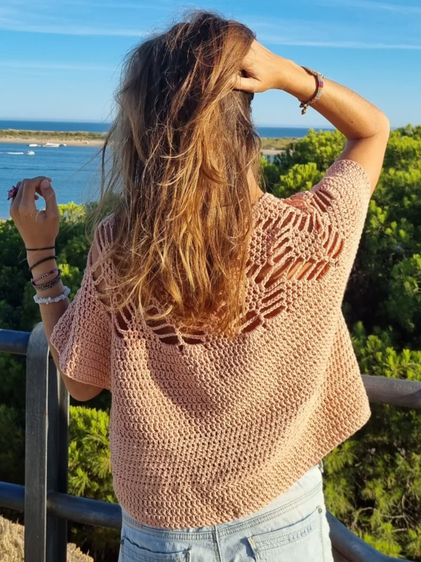 Silvia, artesana de Mostacita Moraíta, frente al mar con un jersey de crochet tejido a mano